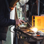 Man welding old shovel, close up